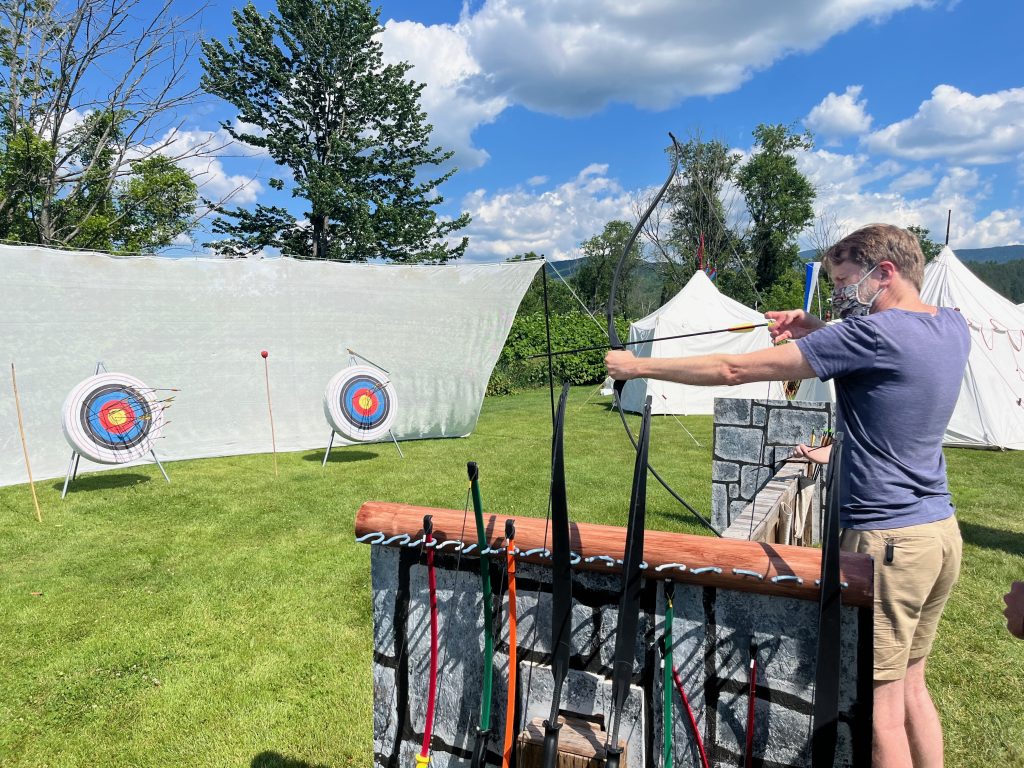 Ken takes aim with a bow and arrow