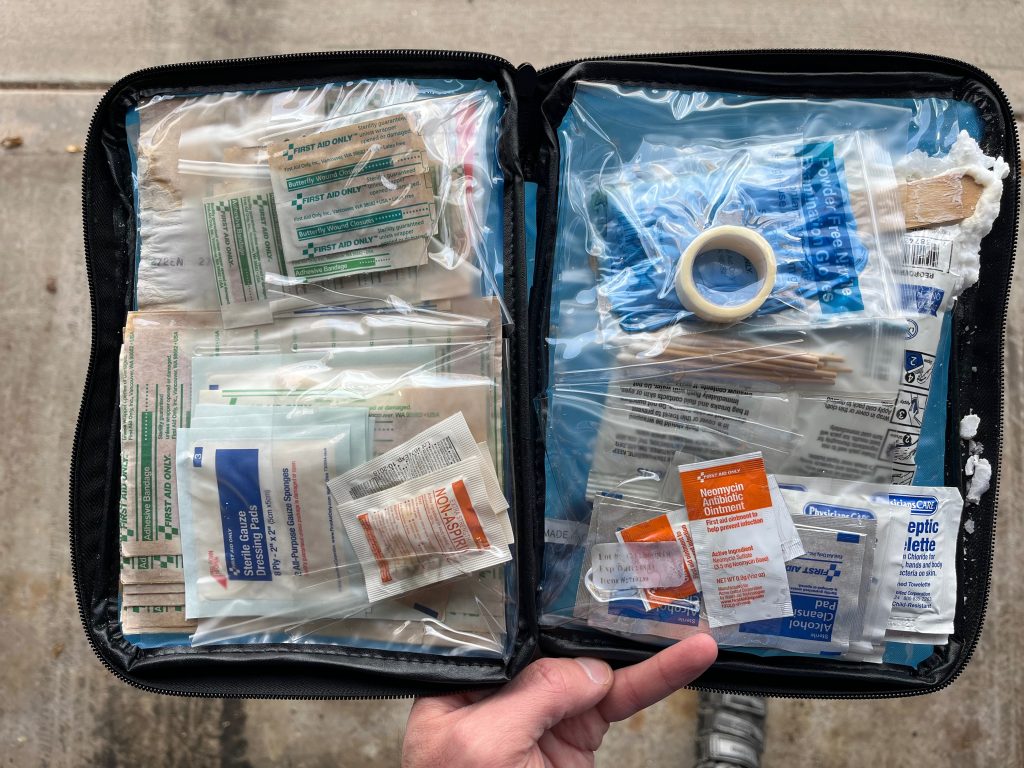 An open pouch with lots of bandages and ointments