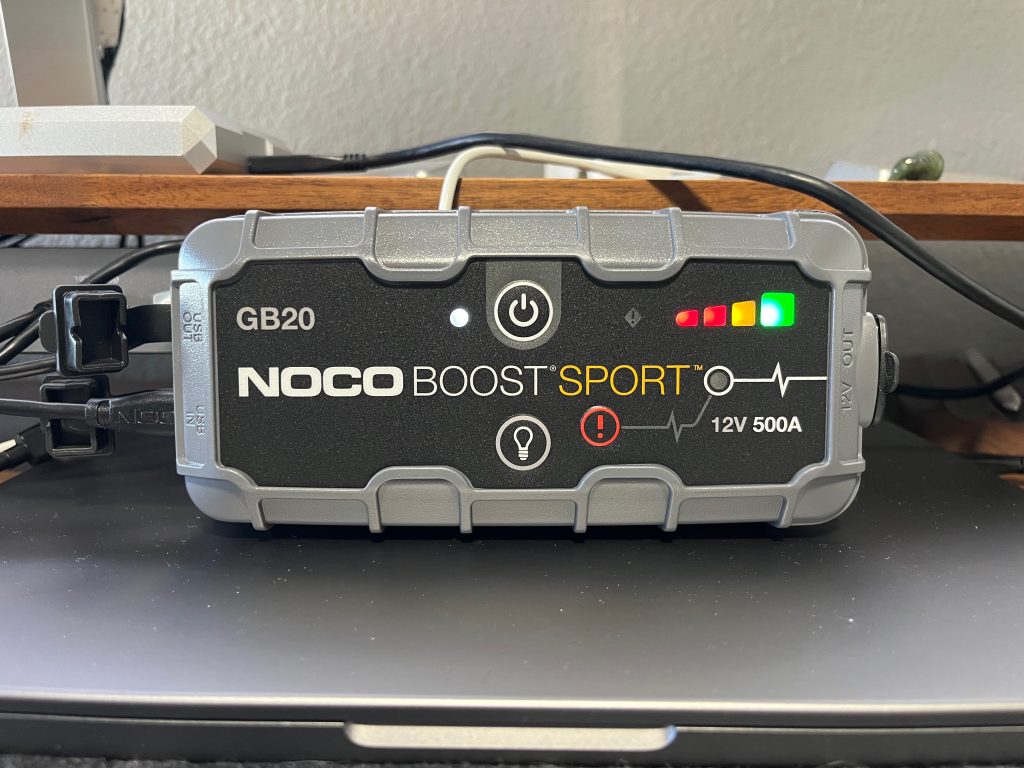 A gray rectangular device with power lights and a USB cable coming out of it