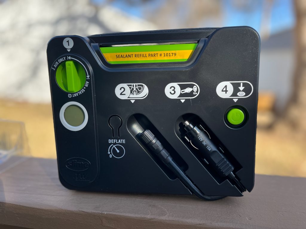 A black rectangle with cables for a car and a cigarette lighter